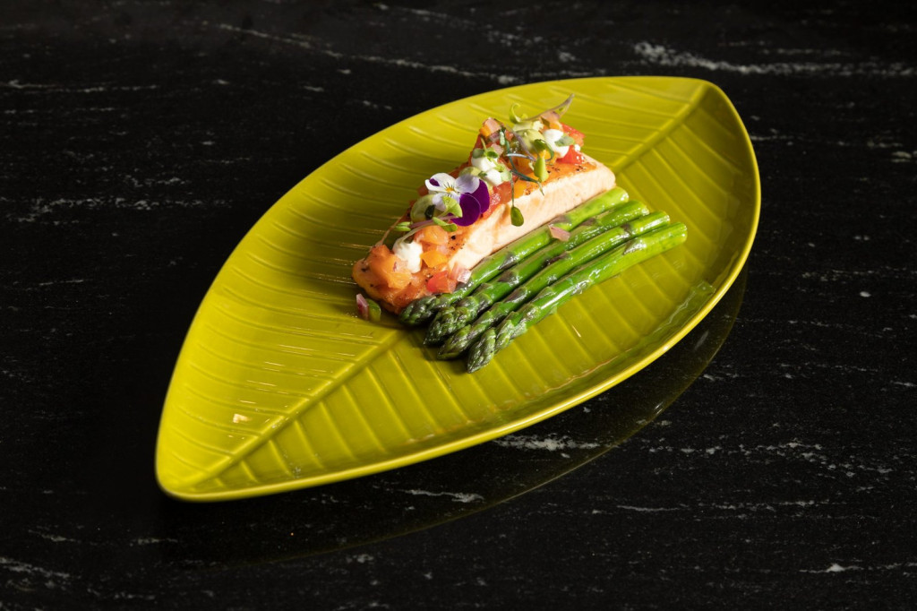 Main dish: salmon with asparagus served on a green leaf-shaped plate at Restaurante Puerto Blanco, Calpe