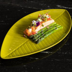 Main dish: salmon with asparagus served on a green leaf-shaped plate at Restaurante Puerto Blanco, Calpe